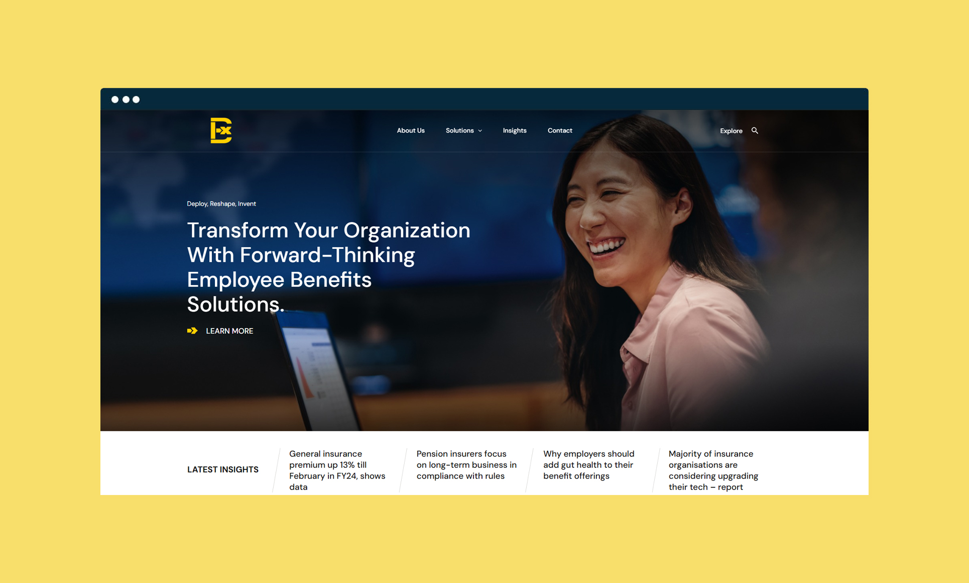 Smiling woman at a desk with a laptop discussing employee benefits solutions.